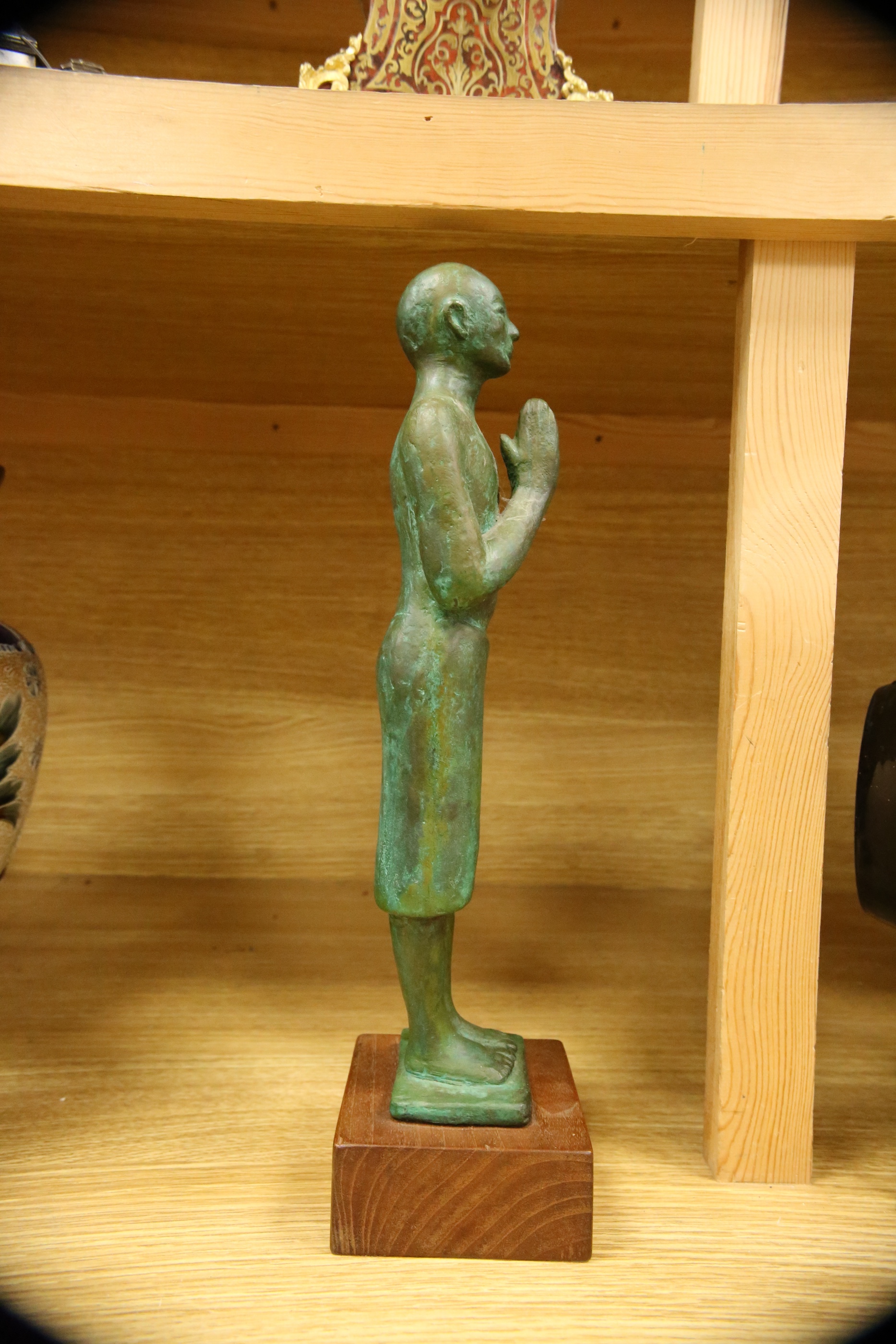 A figural bronze of an Oriental gentleman in prayer, height 42cm including stand. Condition - good